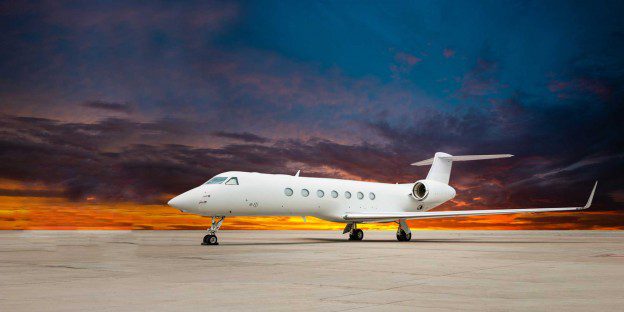 A white jet airplane sitting on top of an airport runway.