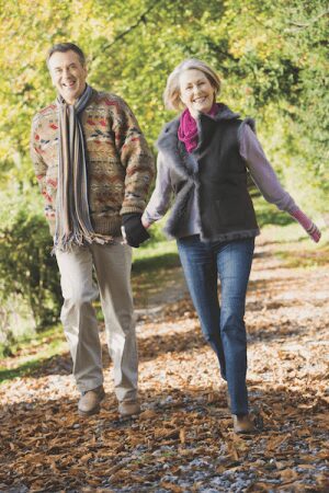 A man and woman walking on the path in the woods.