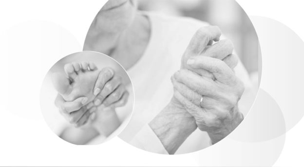 A black and white photo of two hands holding one another.